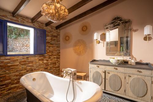 een badkamer met een bad, een wastafel en een spiegel bij CA'N QUINN in Deia