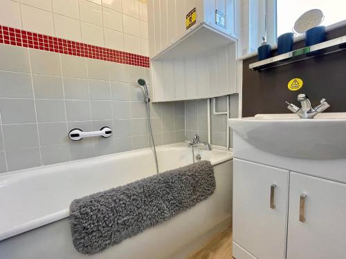 a bathroom with a sink and a tub and a sink at Paradaise Immaculate 2-bed property Hemsby in Hemsby