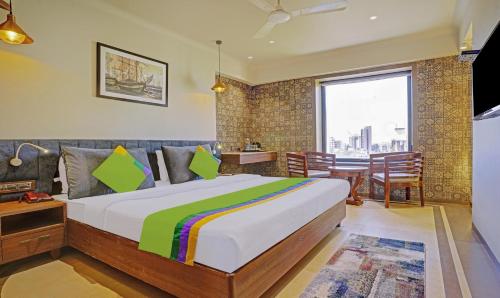 a bedroom with a large bed and a dining room at Treebo Olive Nest in Mumbai