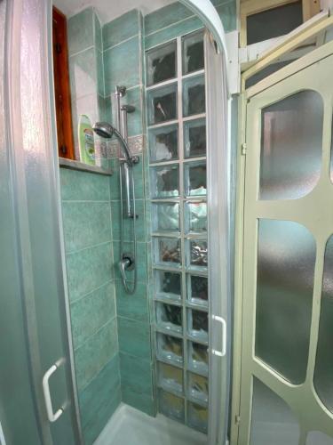 La salle de bains est pourvue d'une douche avec une porte en verre. dans l'établissement Camera Buono, à Ischia