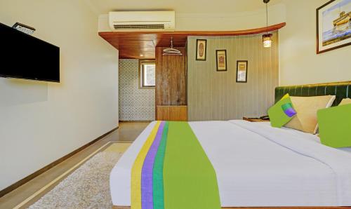 a bedroom with a large bed and a flat screen tv at Treebo Olive Nest in Mumbai