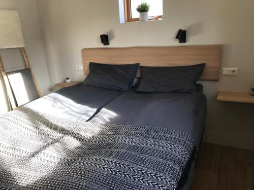 a bedroom with a large bed with a wooden headboard at Áshóll guesthouse - farmstay in Akureyri