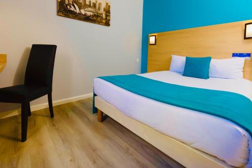 a bedroom with a large bed and a chair at The Originals Access, Hôtel Innostar in Labège
