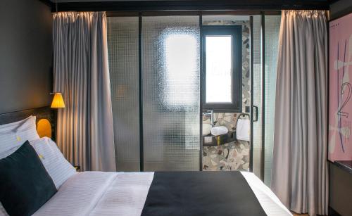 sypialnia z dużym łóżkiem i oknem w obiekcie 3 Pines Design Living w Heraklionie