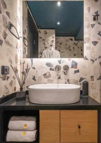 a bathroom with a large white sink and a mirror at 3 Pines Design Living in Heraklio Town