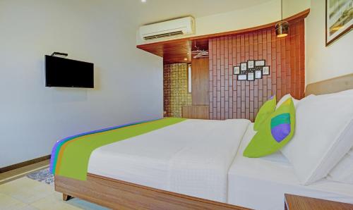 a bedroom with a white bed and a television at Treebo Olive Nest in Mumbai