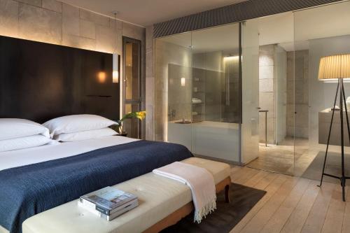 a bedroom with a large bed and a glass shower at Mamilla Hotel in Jerusalem