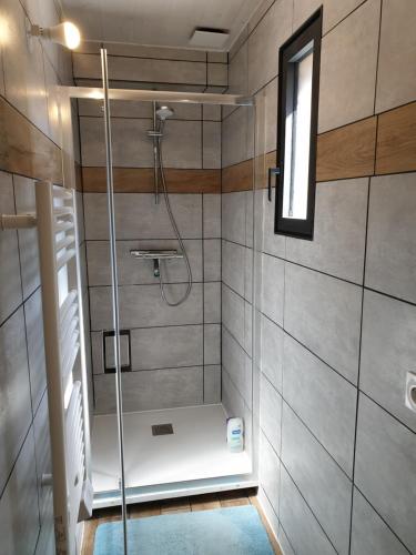 a shower with a glass door in a bathroom at Le Chalet des Roses in Veules-les-Roses
