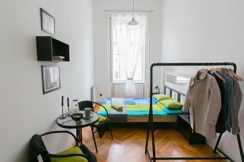 a room with a bed, chair, and a window at Friends Hostel & Apartments in Budapest