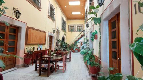 un couloir avec des tables et des chaises dans un bâtiment dans l'établissement OYO Posada Santa Cecilia, Jerez Zacatecas, à Jerez de García Salinas