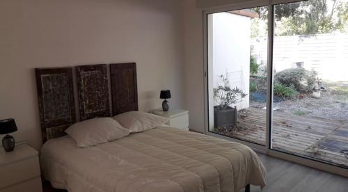 een slaapkamer met een bed en een groot glazen raam bij Entre terre et mer in Pornic