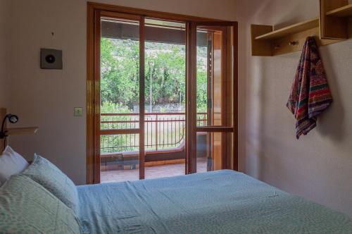 a bedroom with a bed and a view of a balcony at Beach House Blue Holiday in Letojanni