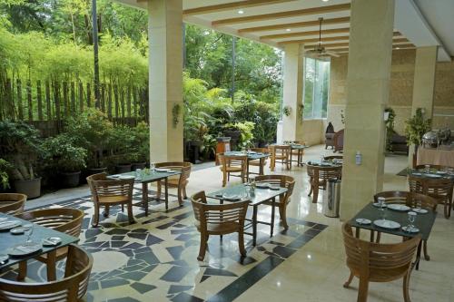 a restaurant with tables and chairs in a courtyard at Marilyn Hotel Serpong in Serpong