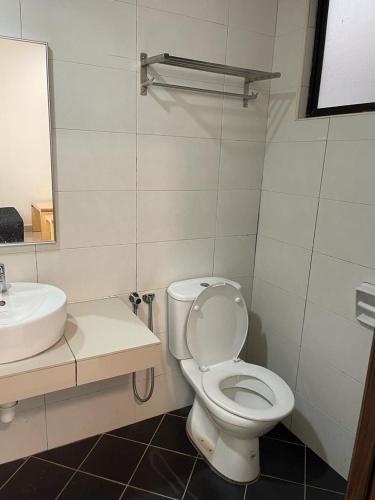ein Badezimmer mit einem weißen WC und einem Waschbecken in der Unterkunft Marina heights hotel residence in Lumut
