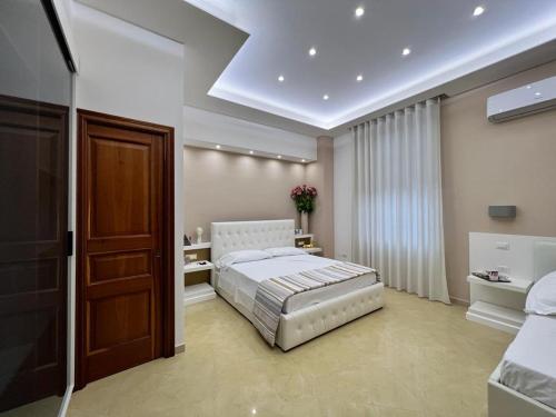 a bedroom with a white bed and a window at Pompei Royal Suite in Pompei