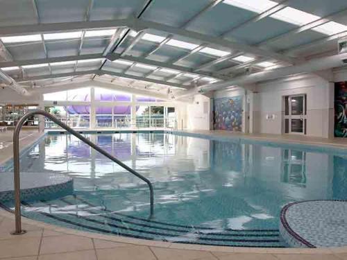 a large indoor swimming pool with blue water at Caravan 66 Kensington at Marton Mere Holiday Park Blackpool in Blackpool