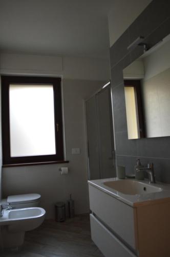 a bathroom with a sink and a toilet and a mirror at Agriturismo La Ca' d'Amelio in Lessolo