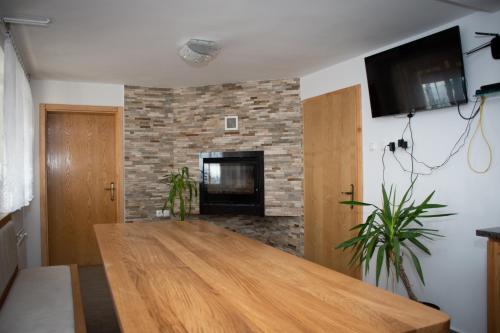 ein Wohnzimmer mit einem Holztisch und einem Kamin in der Unterkunft Vineyard Paradise Senica in Dramlje