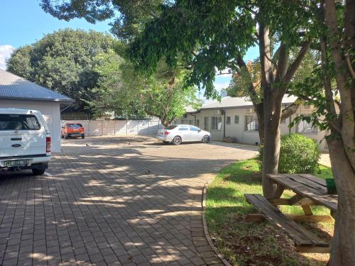 a parking lot with a white car parked in a driveway at Triple9 Hatfield Guesthouse in Pretoria