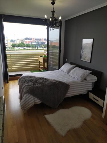 a bedroom with a large bed with a large window at Apartamento Medrano PISCINA AIRE ACONDICIONADO terraza y 5 minutos del centro en coche ideal para mascotas in Logroño