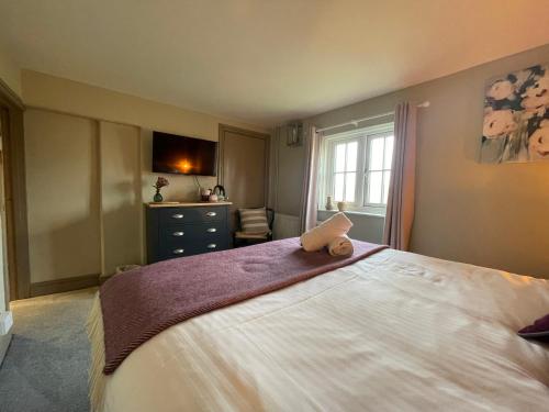 a bedroom with a large white bed and a window at The Windmill Inn in Horsham