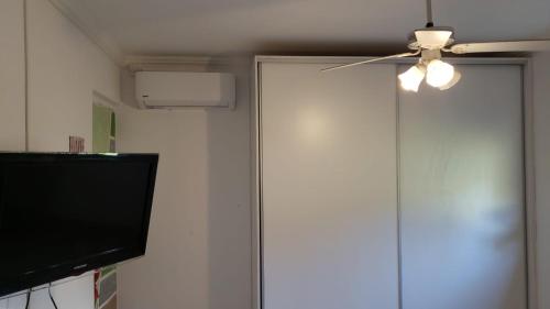 a ceiling fan and a door with a television at Casa San Lorenzo in San Lorenzo