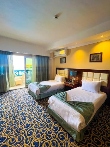 a hotel room with two beds and a balcony at The Guard Hotel in Cairo
