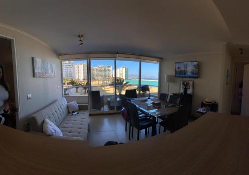 een woonkamer met een bank en een tafel met uitzicht bij Hermoso apartamento de 2 dormitorios y 2 baños en Laguna del Mar La Serena in La Serena