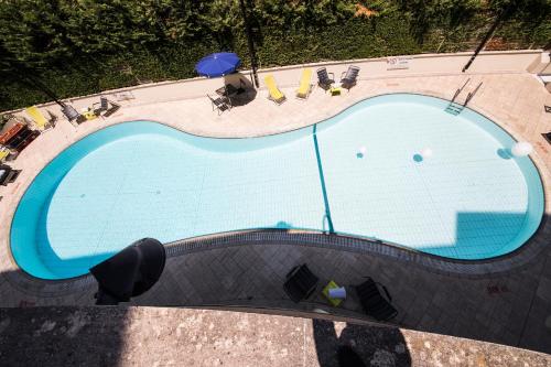 an overhead view of a swimming pool with chairs and umbrellas at Novotel Roma Est in Rome