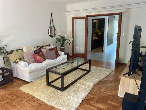 a living room with a couch and a glass coffee table at Excelente Loft con terraza verde y ducha in San Isidro