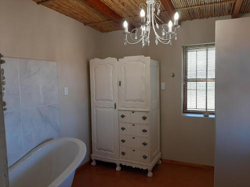 a bathroom with a bath tub and a chandelier at Nieuwedrift accommodation in Piketberg