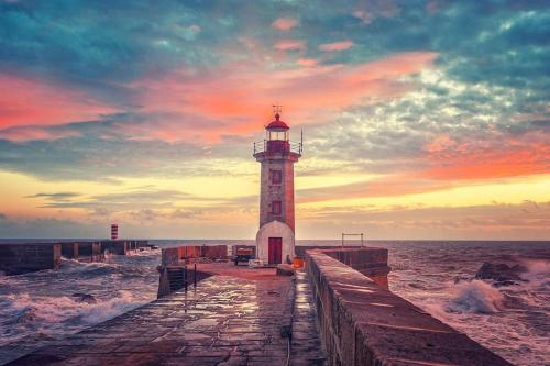a lighthouse on a pier in the ocean with waves at Lighthouse Apartment in Porto