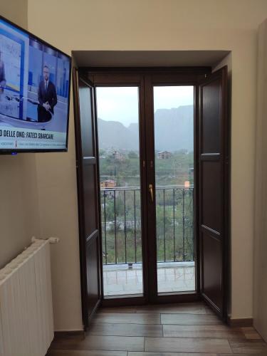 a room with a sliding glass door and a television at Affittacamere Arco Antico in Cusano Mutri