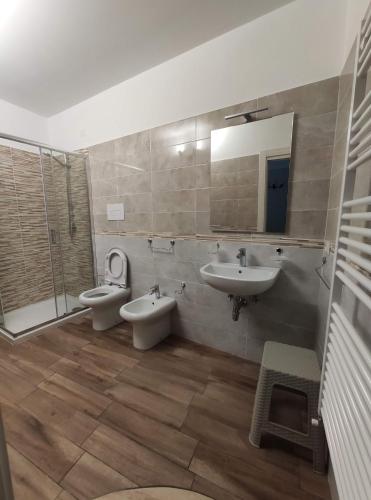 a bathroom with two sinks and a toilet and a mirror at Affittacamere Arco Antico in Cusano Mutri