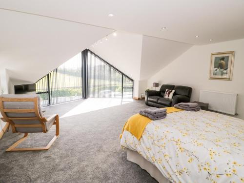 a bedroom with a king sized bed and a chair at The Annexe in Llanfairpwllgwyngyll