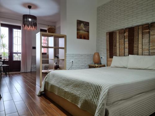 a bedroom with a large bed and a brick wall at L'ISOLA AeR B&B in Lesina