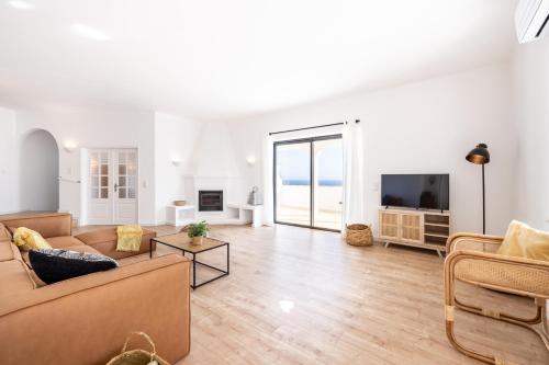a living room with a couch and a tv at Fortaleza sea view Villa Miramar - Apartment with private pool in Budens