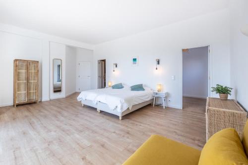 a large white bedroom with a bed and a couch at Fortaleza sea view Villa Miramar - Apartment with private pool in Budens
