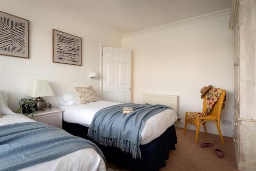 a bedroom with two beds and a chair in it at Uphigh - Elevated Family Home with Stunning River Views in Dartmouth