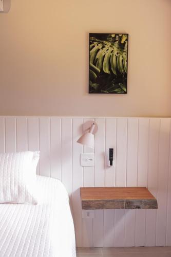 a bedroom with a bed and a table with a lamp at Øko Villa in Juquei