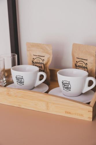 two cups sitting on a wooden shelf at Øko Villa in Juquei