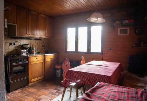 una cocina con mesa y ventana. en Koča pri Binci, en Cerklje na Gorenjskem