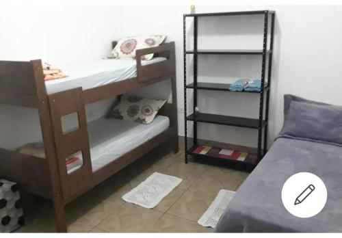 a room with two bunk beds and a bed at Edícula - Casa de hospedes - em Cananeia SP com ar condicionado in Cananéia
