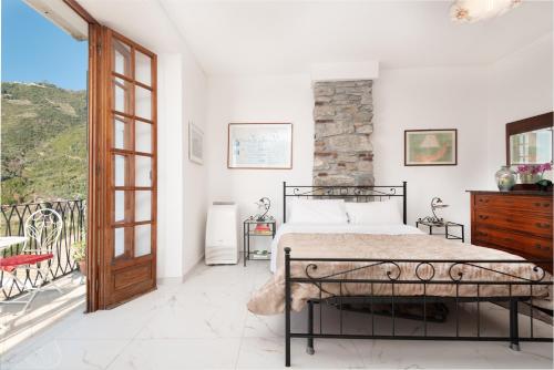 sypialnia z łóżkiem i balkonem w obiekcie Rossi Tramonti 1, w mieście Corniglia