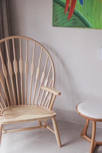 a wooden chair and a table in a room at Øko Villa in Juquei