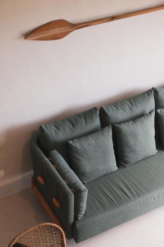 a green couch with pillows on a wall at Øko Villa in Juquei