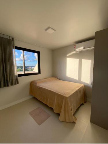 a bedroom with a bed and a window at Condomínio Paraiso dos Coqueiros in Camacari