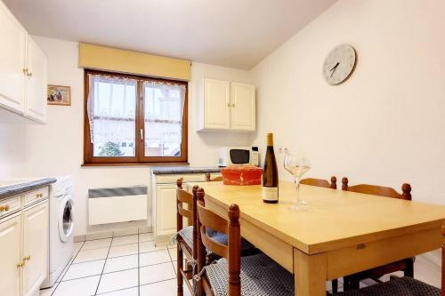- une cuisine avec une table en bois et une bouteille de vin dans l'établissement Chez Romane - appartement avec parking, à Riquewihr