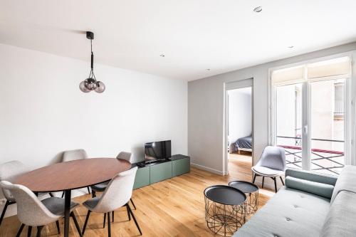 un salon avec une table et des chaises dans l'établissement 127 St Dom - Emplacement parfait - Paris 7ème, à Paris