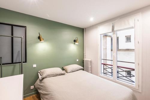 une chambre avec un lit et une fenêtre dans l'établissement 127 St Dom - Emplacement parfait - Paris 7ème, à Paris